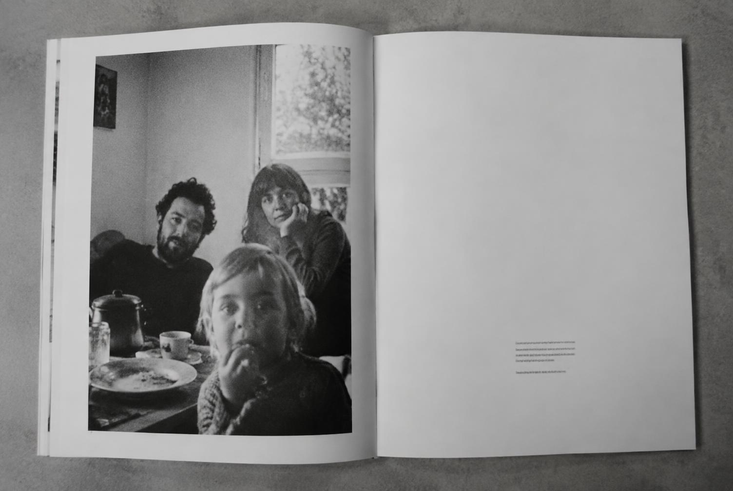 An open memory book spread with a large family photograph on one page and a typeset story on the other