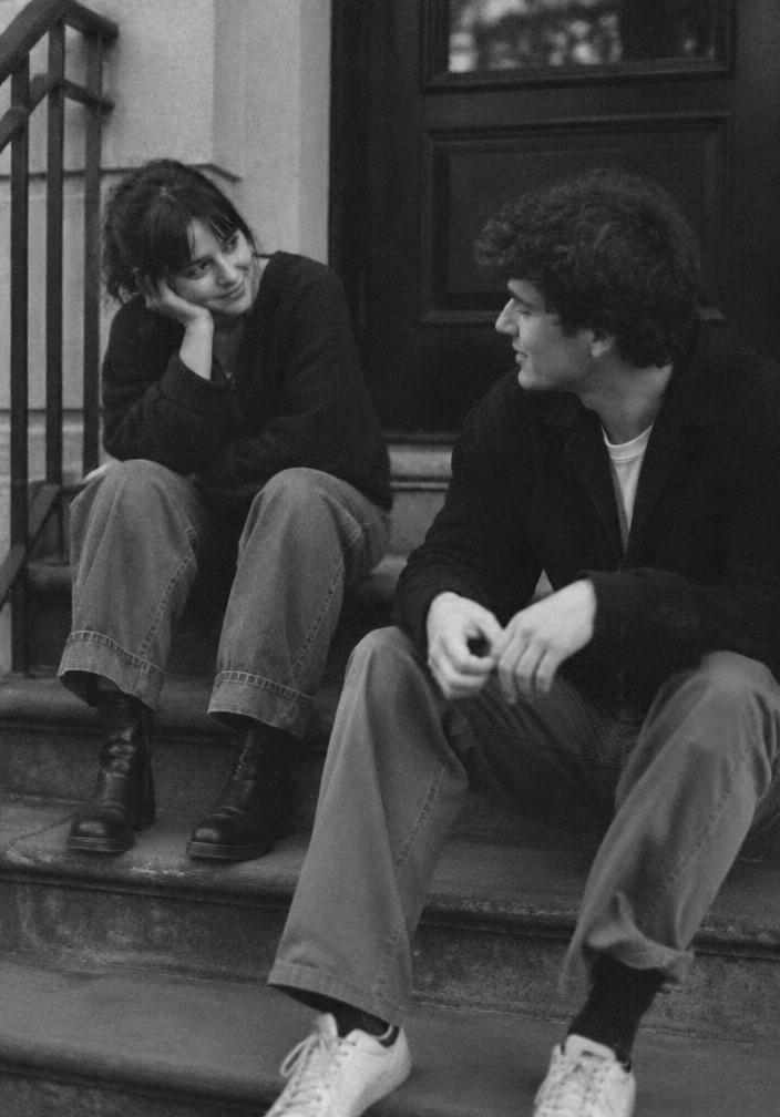 Two friends sitting on outdoor steps mid-conversation